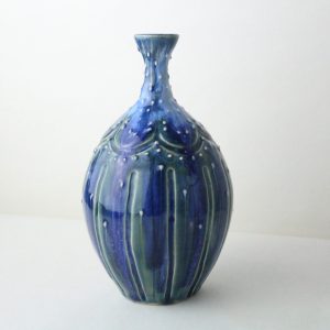 Blue carved bottle vase with slip decoration