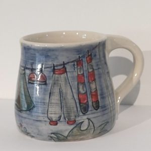 Handmade, carved and decorated stoneware mug with clothes line design